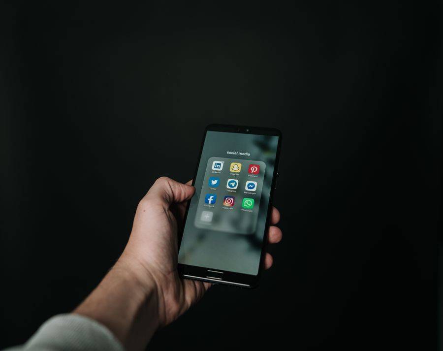 Tangan memegang smartphone dengan layar aplikasi